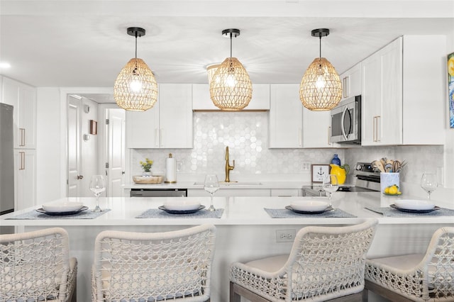 10280 Gulf Blvd Unit 12, Treasure Island, FL 33706 - kitchen featuring appliances with stainless steel finishes, light countertops, and a breakfast bar