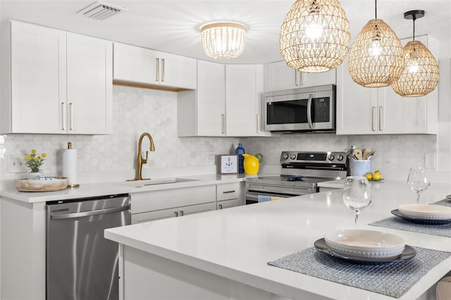 10280 Gulf Blvd Unit 12, Treasure Island, FL 33706 - kitchen featuring stainless steel appliances, light countertops, white cabinets, and backsplash