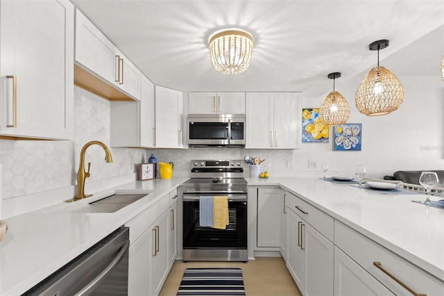 10280 Gulf Blvd Unit 12, Treasure Island, FL 33706 - kitchen featuring appliances with stainless steel finishes, a chandelier, tasteful backsplash, light countertops, and white cabinets