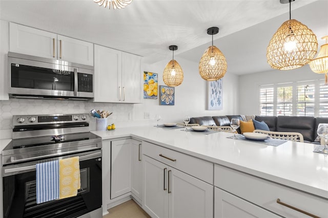 10280 Gulf Blvd Unit 12, Treasure Island, FL 33706 - kitchen featuring stainless steel appliances, open floor plan, decorative backsplash, light countertops, and vaulted ceiling