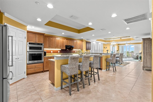 3805 Gulf Blvd Unit 401, St Pete Beach, FL 33706 - kitchen featuring crown molding, a tray ceiling, appliances with stainless steel finishes, recessed lighting, and a kitchen island