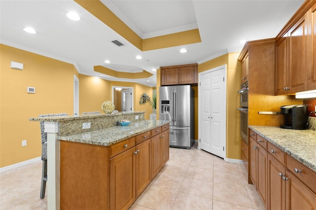 3805 Gulf Blvd Unit 401, St Pete Beach, FL 33706 - kitchen with high end fridge, a raised ceiling, a kitchen bar, crown molding, and a kitchen island