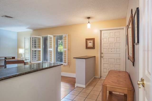 2421 Eagle Chase Dr, Palm Harbor, FL 34683 - kitchen with dark countertops, a textured ceiling, light tile patterned floors, and pendant lighting
