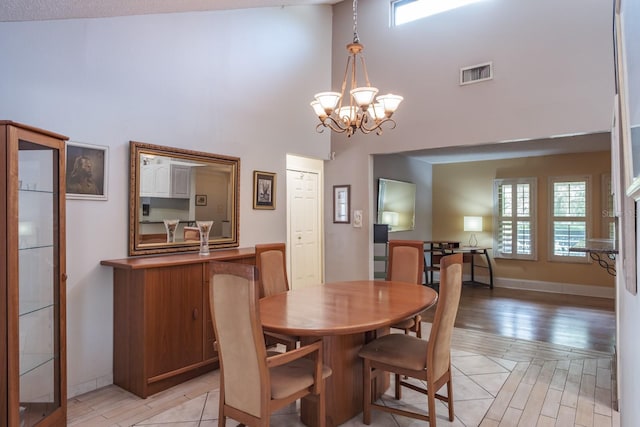 2421 Eagle Chase Dr, Palm Harbor, FL 34683 - dining area with a high ceiling, a chandelier, and light wood-style flooring