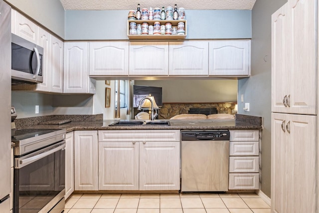 2421 Eagle Chase Dr, Palm Harbor, FL 34683 - kitchen featuring appliances with stainless steel finishes, a textured ceiling, white cabinets, light tile patterned flooring, and dark stone countertops