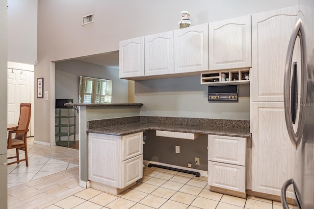 2421 Eagle Chase Dr, Palm Harbor, FL 34683 - kitchen with light tile patterned floors, stainless steel refrigerator, a peninsula, white cabinetry, and a towering ceiling