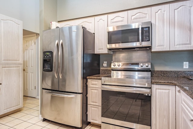2421 Eagle Chase Dr, Palm Harbor, FL 34683 - kitchen featuring stainless steel appliances, light tile patterned flooring, dark stone counters, and white cabinets