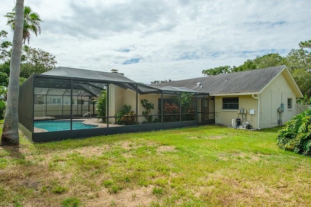 2421 Eagle Chase Dr, Palm Harbor, FL 34683 - back of property featuring a lawn, stucco siding, and glass enclosure