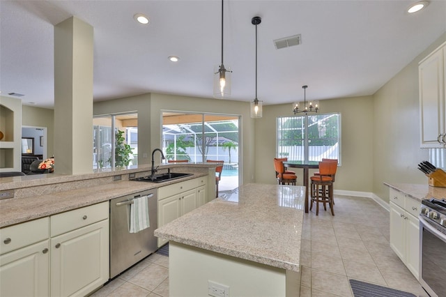 12305 Freesia Ct, Riverview, FL 33569 - kitchen featuring stainless steel appliances, light tile patterned floors, recessed lighting, white cabinets, and a center island