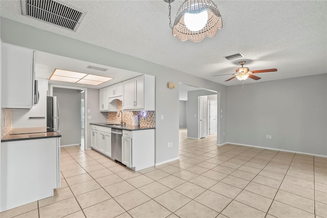 7108 14th Ave NW, Bradenton, FL 34209 - kitchen featuring appliances with stainless steel finishes, dark countertops, light tile patterned floors, ceiling fan, and a textured ceiling