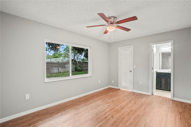 7108 14th Ave NW, Bradenton, FL 34209 - unfurnished bedroom featuring light wood finished floors, a textured ceiling, ensuite bath, a closet, and ceiling fan