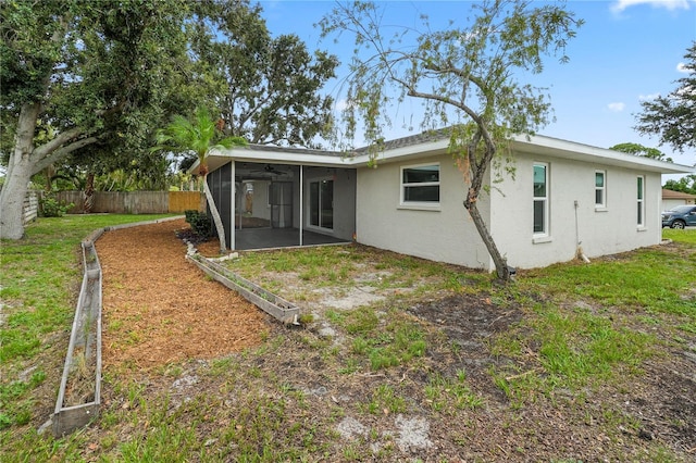7108 14th Ave NW, Bradenton, FL 34209 - back of house with a sunroom, stucco siding, and a ceiling fan