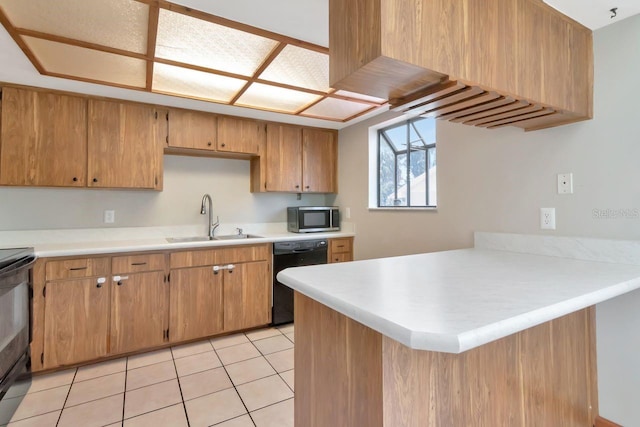 9501 Alice Ln, Riverview, FL 33578 - kitchen with black appliances, a peninsula, light countertops, light tile patterned floors, and brown cabinets