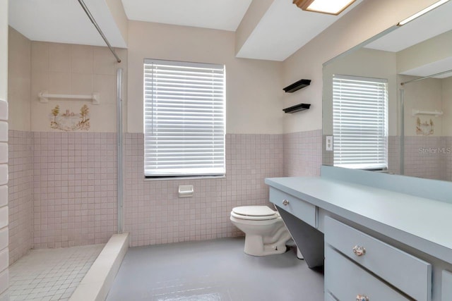 9501 Alice Ln, Riverview, FL 33578 - bathroom featuring tile walls, tiled shower, healthy amount of natural light, a wainscoted wall, and vanity