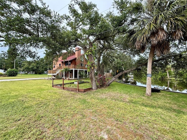 9501 Alice Ln, Riverview, FL 33578 - view of green lawn with a garden, a deck with water view, and stairway