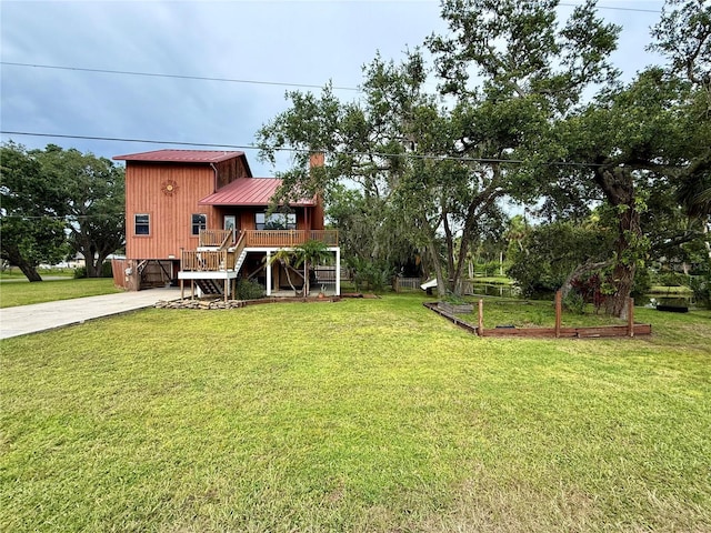 9501 Alice Ln, Riverview, FL 33578 - view of green lawn with stairs, driveway, a vegetable garden, and a porch