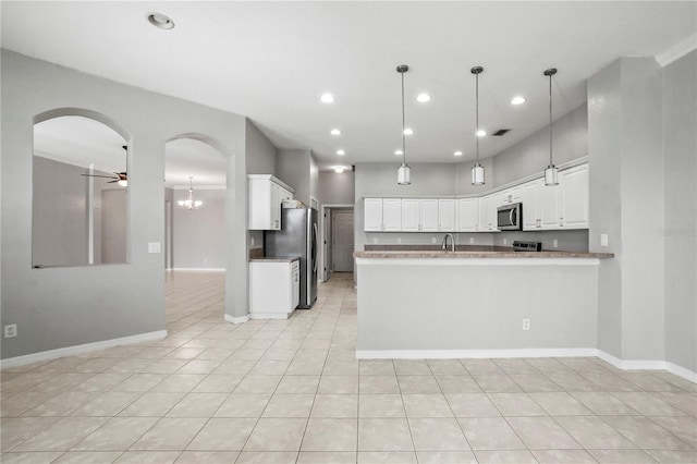 11810 Holly Creek Dr, Riverview, FL 33569 - kitchen featuring stainless steel appliances, white cabinets, arched walkways, a ceiling fan, and recessed lighting