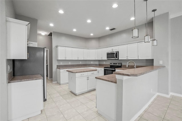 11810 Holly Creek Dr, Riverview, FL 33569 - kitchen with appliances with stainless steel finishes, light tile patterned floors, a peninsula, white cabinets, and recessed lighting