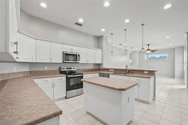 11810 Holly Creek Dr, Riverview, FL 33569 - kitchen with appliances with stainless steel finishes, a peninsula, light tile patterned floors, a center island, and white cabinetry