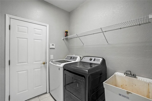 11810 Holly Creek Dr, Riverview, FL 33569 - laundry area with washer and clothes dryer, a textured wall, and light tile patterned floors