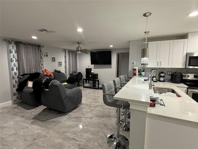 2927 W Henry Ave, Tampa, FL 33614 - living room featuring a ceiling fan, recessed lighting, and light marble finish floors