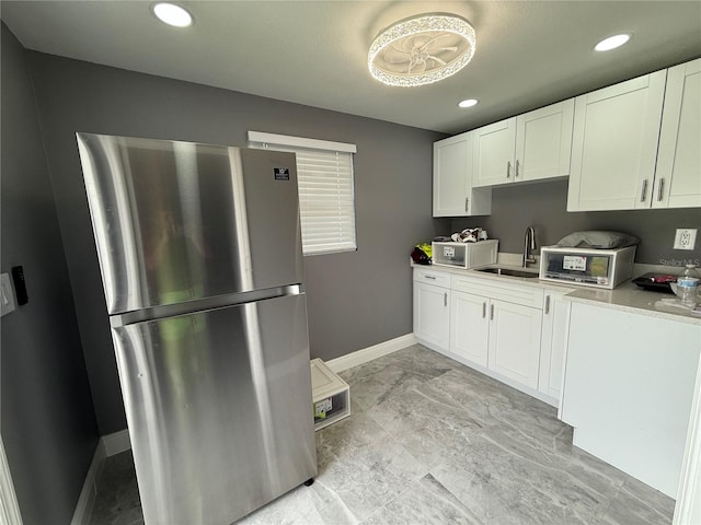 2927 W Henry Ave, Tampa, FL 33614 - kitchen with freestanding refrigerator, white cabinets, light countertops, and recessed lighting