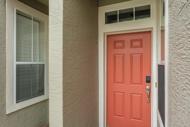 3298 Covered Bridge Dr W, Dunedin, FL 34698 - view of exterior entry with stucco siding