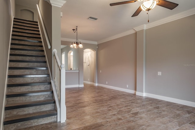 3298 Covered Bridge Dr W, Dunedin, FL 34698 - stairs with arched walkways, ceiling fan, ornamental molding, wood finished floors, and a chandelier