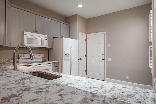 3298 Covered Bridge Dr W, Dunedin, FL 34698 - kitchen featuring white appliances, gray cabinets, light stone counters, and recessed lighting