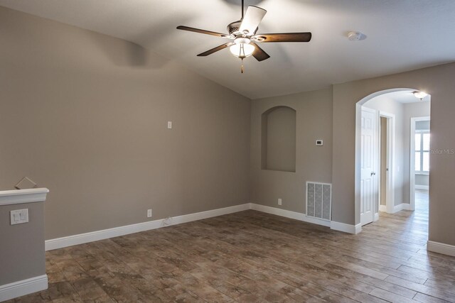 3298 Covered Bridge Dr W, Dunedin, FL 34698 - spare room with arched walkways, a smoke detector, a ceiling fan, lofted ceiling, and wood finished floors