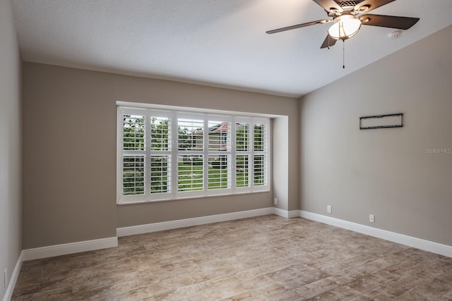 3298 Covered Bridge Dr W, Dunedin, FL 34698 - empty room featuring light wood finished floors, a ceiling fan, a smoke detector, and vaulted ceiling