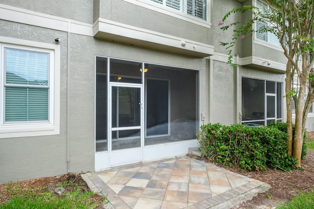 3298 Covered Bridge Dr W, Dunedin, FL 34698 - entrance to property with stucco siding and a patio area