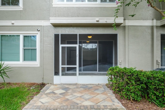 3298 Covered Bridge Dr W, Dunedin, FL 34698 - property entrance featuring stucco siding and a patio area