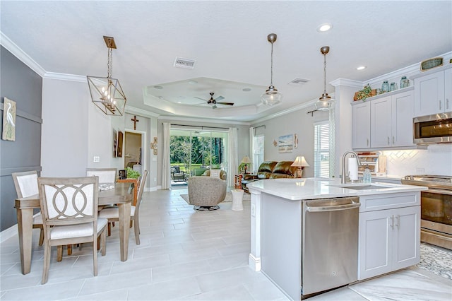 13621 Circa Crossing Dr, Lithia, FL 33547 - kitchen with appliances with stainless steel finishes, ornamental molding, healthy amount of natural light, a ceiling fan, and light countertops
