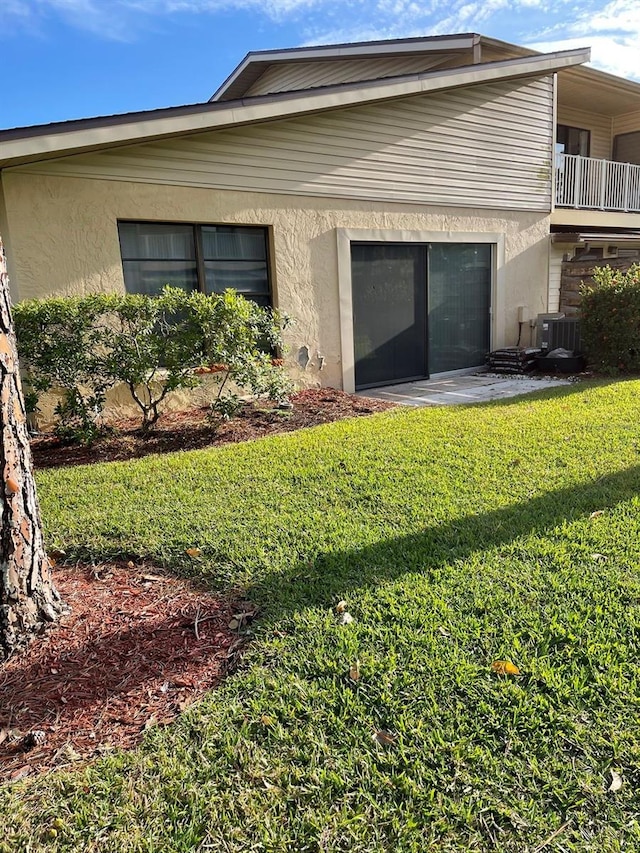 3610 54th St W Unit B8, Bradenton, FL 34209 - view of side of home featuring stucco siding, a lawn, and a balcony