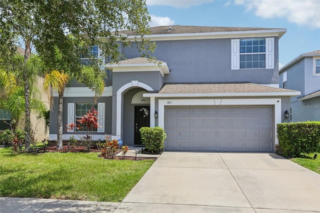 1811 Palm Warbler Ln, Ruskin, FL 33570 - view of front facade with driveway, a front lawn, a garage, and stucco siding