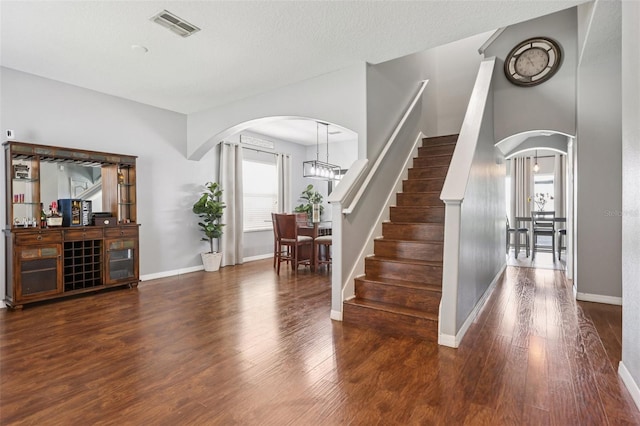 1811 Palm Warbler Ln, Ruskin, FL 33570 - staircase with arched walkways, wood finished floors, and a chandelier