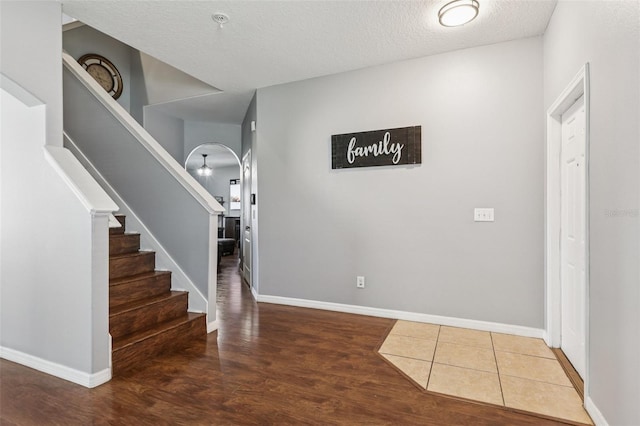 1811 Palm Warbler Ln, Ruskin, FL 33570 - foyer entrance featuring stairs, arched walkways, wood finished floors, and a textured ceiling