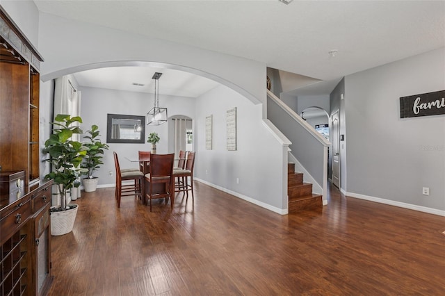 1811 Palm Warbler Ln, Ruskin, FL 33570 - dining room featuring dark wood-type flooring, arched walkways, stairway, and healthy amount of natural light