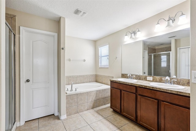 1811 Palm Warbler Ln, Ruskin, FL 33570 - bathroom featuring tile patterned floors, a shower stall, double vanity, a garden tub, and a textured ceiling