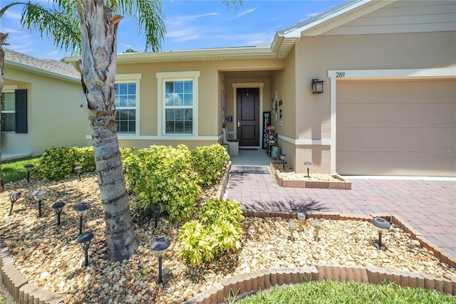 289 Siesta Vista Ct, Davenport, FL 33896 - property entrance featuring stucco siding, an attached garage, and driveway