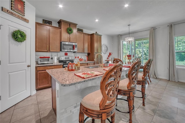 289 Siesta Vista Ct, Davenport, FL 33896 - kitchen with stainless steel appliances, brown cabinets, recessed lighting, decorative backsplash, and light stone counters