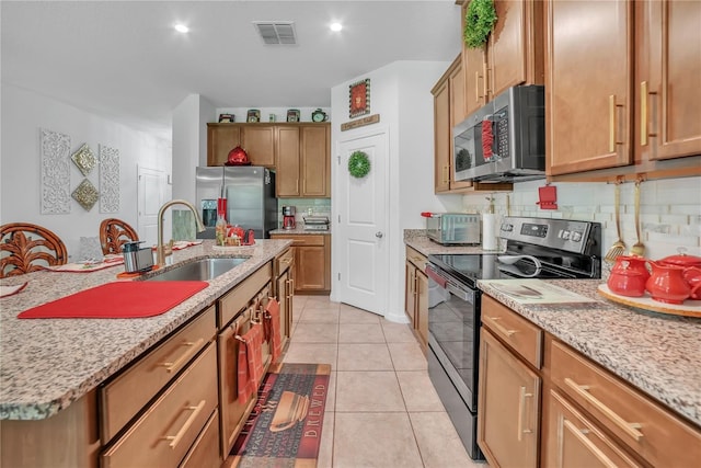 289 Siesta Vista Ct, Davenport, FL 33896 - kitchen featuring appliances with stainless steel finishes, tasteful backsplash, light stone countertops, light tile patterned flooring, and recessed lighting