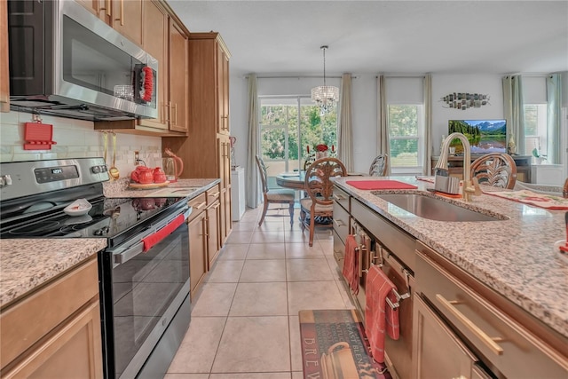 289 Siesta Vista Ct, Davenport, FL 33896 - kitchen with stainless steel appliances, light tile patterned floors, backsplash, and light stone countertops