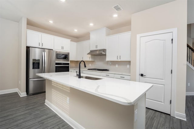 7728 Somersworth Dr, Kissimmee, FL 34747 - kitchen with appliances with stainless steel finishes, under cabinet range hood, dark wood-style flooring, white cabinetry, and recessed lighting