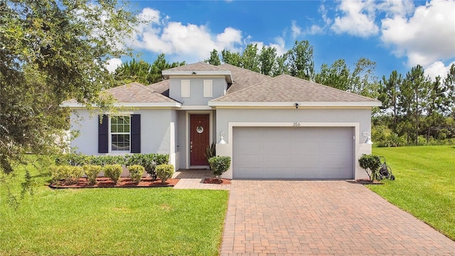 356 Irving Bend Dr, Groveland, FL 34736 - view of front of house with stucco siding, decorative driveway, an attached garage, a shingled roof, and a front yard