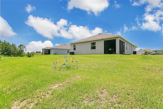 356 Irving Bend Dr, Groveland, FL 34736 - rear view of house with stucco siding and a lawn