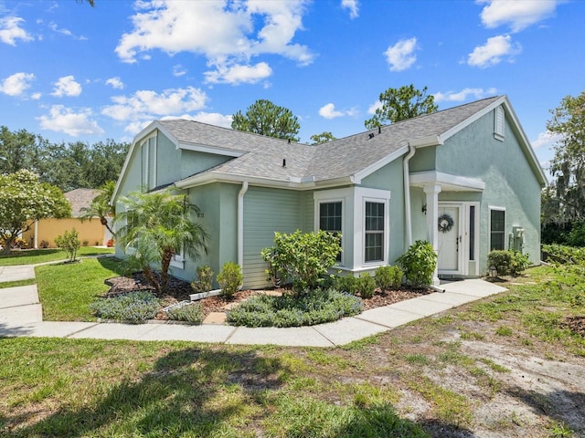 4220 Revere Cir, New Port Richey, FL 34653 - view of front of home featuring stucco siding, roof with shingles, and a front lawn