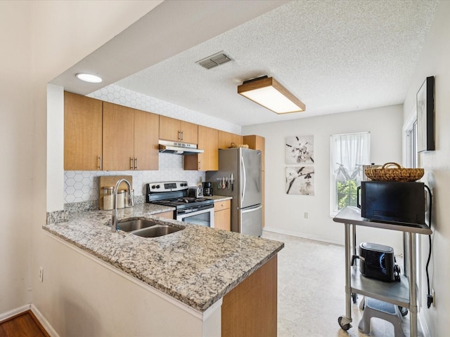 4220 Revere Cir, New Port Richey, FL 34653 - kitchen featuring stainless steel appliances, under cabinet range hood, light stone counters, decorative backsplash, and a peninsula