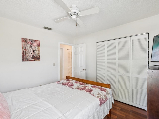 4220 Revere Cir, New Port Richey, FL 34653 - bedroom featuring dark wood-style flooring, a closet, ceiling fan, and a textured ceiling